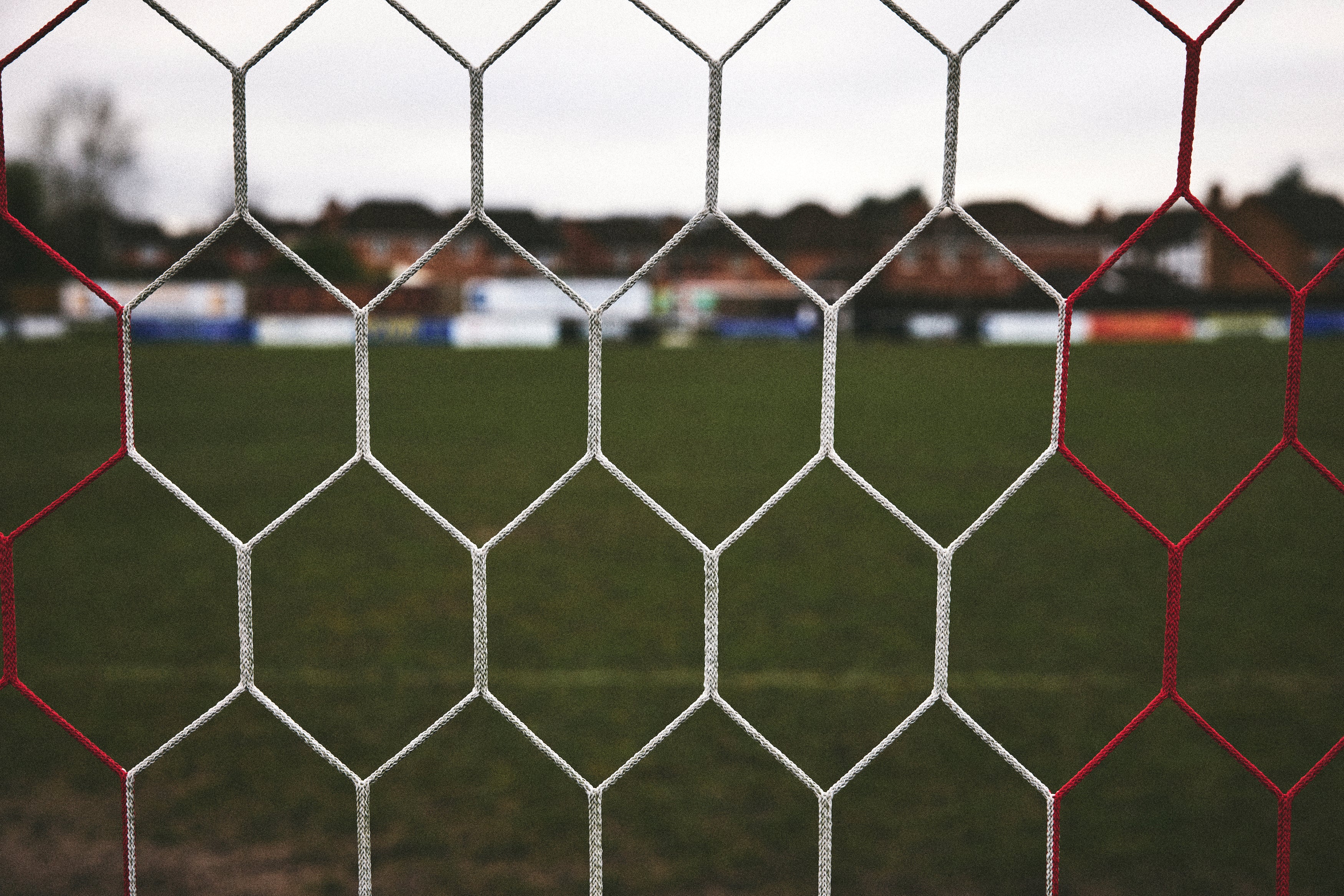 Soccer net with a blurred sports field background
