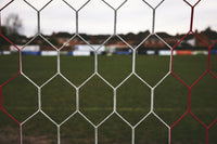 Soccer net with a blurred sports field background
